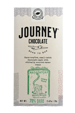 Load image into Gallery viewer, A large size packaged Journey Chocolate bar in an off-white cardboard box with wavy US postal service lines across the top, lower sides and bottom of the box. A white postage stamp style seal with a cacao pod in the middle seals the box, with the words &quot;Experts in small-batch, craft chocolate&quot; in a circle around the image and the words &quot;Seal of Quality&quot; at the bottom. The Journey Chocolate logo is centered on the bar and an Madagascar 70% dark stamp centered on the bottom, net weight 2.47 oz or 70 grams
