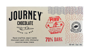 A medium size packaged Journey Chocolate bar in an off-white cardboard box with wavy US postal service lines across the top and right sides of the box. A white postage stamp style seal with a cacao pod in the middle seals the box, with the words "Experts in small-batch, craft chocolate" in a circle around the image and the words "Seal of Quality" at the bottom. The journey chocolate logo is on the left side of the  bar and an Peru 70% dark stamp centered in the middle, net weight 1.0 oz or 28 grams.